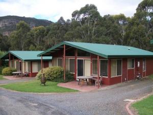 霍尔斯加普Halls Gap Valley Lodges的红色的房子,有绿色的屋顶和野餐桌