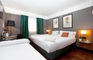 瓦伦西亚马尔科姆和巴瑞特酒店的配有绿窗帘的酒店客房的两张床