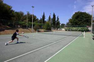 博尔马斯·莱斯·米默萨斯Village Vacances La Manne的在网球场打网球的男人