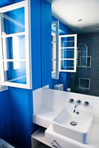 科尼尔-德拉弗龙特拉Hostal El Alojado de Velarde的浴室设有蓝色的墙壁和白色的盥洗盆。