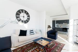 阿西西Sunset House La Terrazza的客厅配有白色沙发和墙上的时钟
