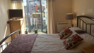 斯陶尔波特River view Apartment的一间卧室设有一张带电视和窗户的床。