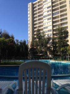 阿尔加罗沃Costa Algarrobo Norte的游泳池前的白色椅子