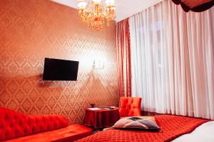 汉堡山村酒店的一间卧室配有一张红色的床和吊灯。