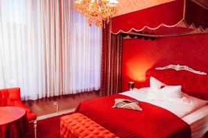 汉堡山村酒店的红色卧室配有一张床和一个吊灯
