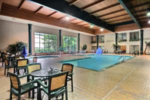 麦迪逊麦迪逊西/米德尔顿WI西贝蒙特旅馆及套房酒店的室内游泳池配有桌椅、桌子和餐桌以及糕点店