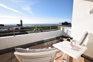 韦斯特兰叙尔特岛维京酒店的阳台配有桌椅,享有海景。