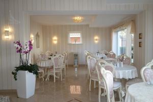 基尔戈德温德酒店的用餐室配有白色的桌椅和鲜花