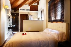 Arcos de las Salinas兹尔泽加瓦拉姆布雷酒店的一间卧室配有一张白色的床铺,上面有红玫瑰