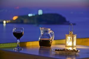 纳克索乔拉格罗塔酒店的一张桌子,上面放着一杯葡萄酒和一杯饮料