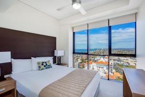 黄金海岸曼特拉塞拉豪华酒店的一间卧室设有一张大床和大窗户