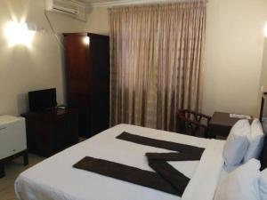 马普托Pensao Marhaba Residencial的一间卧室配有一张床、一张书桌和一个窗户。