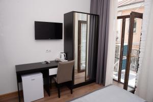巴统Guest House Gantiadi的客房设有书桌、电视和窗户。