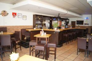 科隆阿卡兹恩鸿丰酒店的餐厅内的酒吧配有木桌和椅子