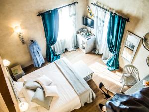 维托里奥·威尼托爱丽丝瑞莱斯内勒维涅住宿加早餐旅馆的一间卧室配有一张带蓝色窗帘的大床
