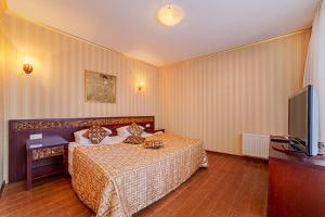 敖德萨巴拿马别墅的一间卧室配有一张床和一台平面电视