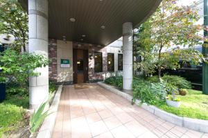 名古屋名古屋荣东R&B酒店的柱子和植物的建筑物入口