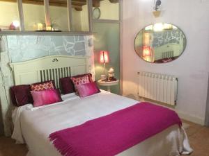 巴基奥Bisalde的一间卧室配有一张大床、紫色枕头和镜子