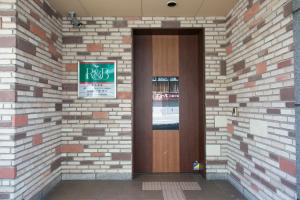 名古屋R&B Hotel Nagoya Nishiki的砖墙上一扇门,上面有标志