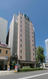 名古屋R&B Hotel Nagoya Nishiki的一座高大的棕褐色建筑,上面有标志