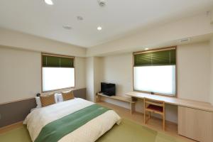 三岛市休美坎酒店的一间卧室配有一张床、一张书桌和两个窗户。