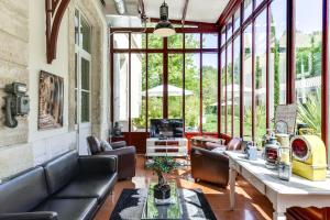 索米耶尔艾斯德鲁酒店的客厅配有皮革家具和大窗户