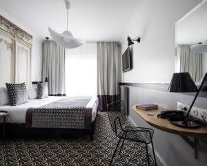 巴黎马尔特阿斯托特尔酒店的配有一张床和一张书桌的酒店客房