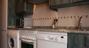 拉斯卡弗里亚Zaguan的厨房配有白色家电和木制橱柜
