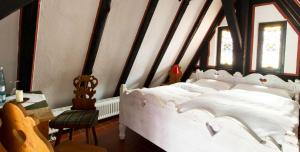 Bad EmstalHotel Der Grischäfer的卧室配有白色的床和桌椅