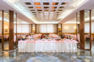 卡迈格拉特罗希拉诺塔索酒店的宴会厅配有粉红色的桌椅