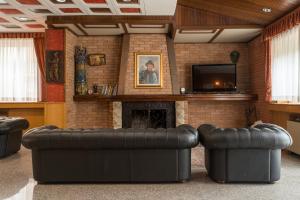 卡迈格拉特罗希拉诺塔索酒店的客厅配有2张真皮沙发和壁炉