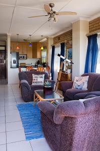 阿曼济姆托蒂Seven Seas SA的客厅配有紫色沙发和桌子