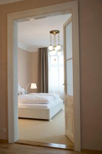 维也纳安塞尔复古客房酒店的一间卧室配有一张床和一个吊灯