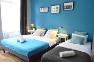 波兹南花卉公寓旅馆的蓝色墙壁客房的两张床