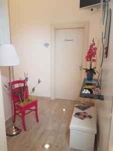 切萨雷奥港Di Ma B&B的一间设有红色椅子、桌子和门的房间