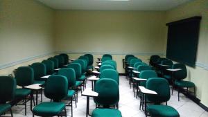 里约布兰科Hotel Majú的一个配有绿色椅子和粉笔板的空教室