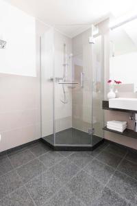 埃斯林根MAVO Hospitality by Büroma Apart Apartmentvermietung GmbH Esslingen的一间带玻璃淋浴和水槽的浴室