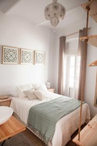 塔里法2 - LA ESQUINA AZUL de TARIFA - ENJOY TARIFA的白色卧室配有一张床和一个吊灯
