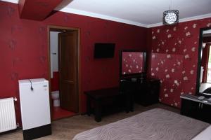 SamtrediaHotel Obola的卧室设有红色墙壁和白色冰箱