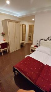 新戈里察斯特科旅馆的一间卧室配有一张带红色毯子的大床