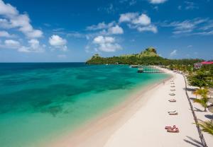 格罗斯岛Sandals Grande St. Lucian Spa and Beach All Inclusive Resort - Couples Only的享有带椅子的海滩和大海的景致。