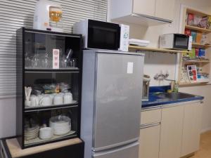 东京背包客米尼旅舍的厨房配有冰箱,上面配有微波炉