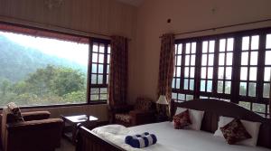 马迪凯里Abiyal Mountain Stay的一间卧室设有一张床和两个大窗户
