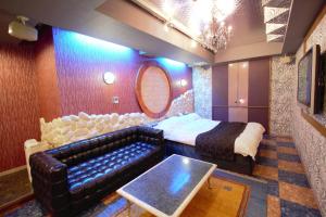 堺市拉拉酒店（仅限成人）的一间带沙发、床和桌子的卧室