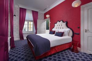 格丁尼亚Relais & Châteaux Hotel Quadrille - Adults Only的一间卧室设有一张带红色墙壁的大床