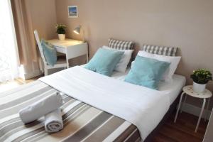 波兹南花卉公寓旅馆的一间卧室配有一张带蓝色枕头的床