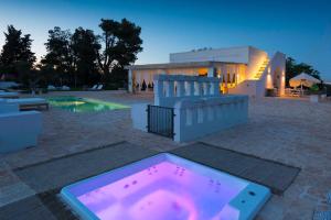 洛科罗通多Tenuta del Lauro的房屋前设有带热水浴池的游泳池