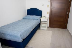 廖洛泰尔梅克里斯塔洛酒店的一间卧室配有蓝色的床和床头柜