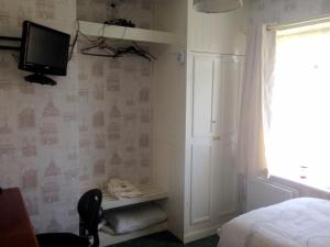 斯皮克利物浦机场民宿的一间卧室配有一张床,墙上配有电视
