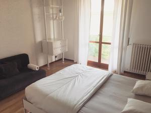 皮耶韦埃马努埃莱Sunny family apartment in villa - HUMANITAS FORUM IEO的一间卧室配有一张床、一张沙发和一个窗口